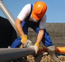 a Seal Beach plumber is tightening a commercial pipe